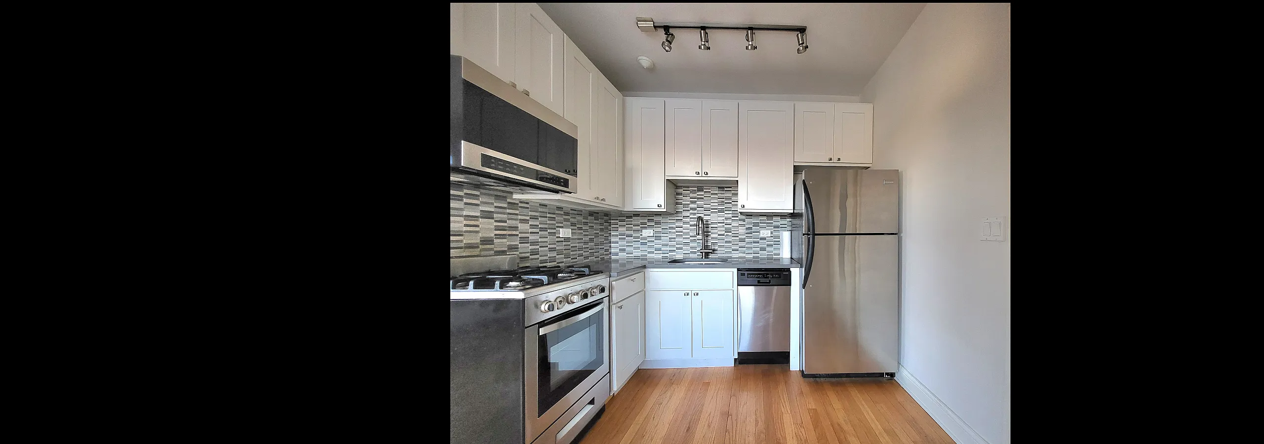 Modern kitchen with sleek stainless steel appliances, chic tile backsplash, and elegant white cabinetry, perfect for culinary enthusiasts.