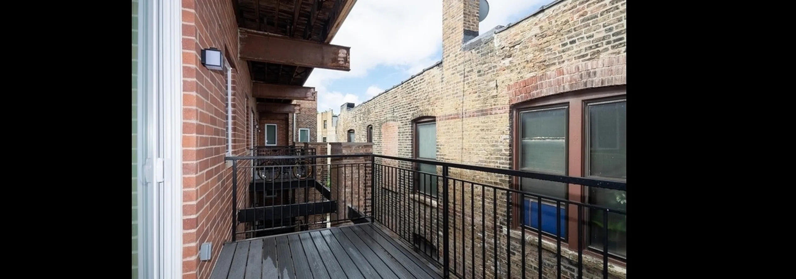 Charming urban balcony with sleek railing and beautiful brickwork, offering a cozy outdoor escape in a vibrant city setting.