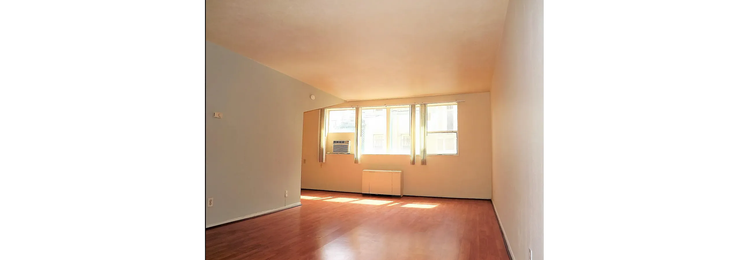Bright and airy living space with large windows, sleek hardwood floors, and abundant natural light.