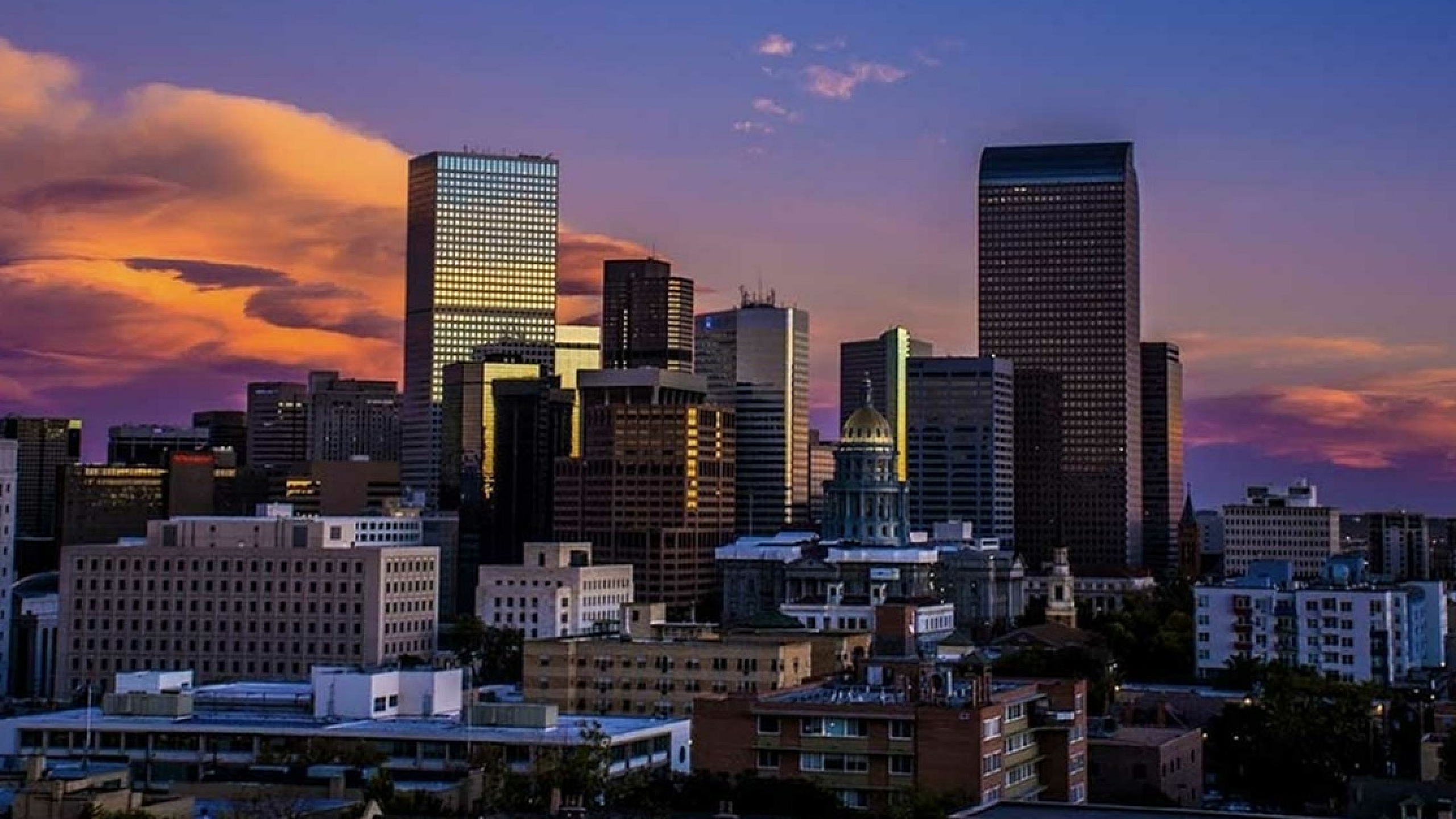 Breathtaking city skyline at sunset with vibrant hues illuminating modern skyscrapers.