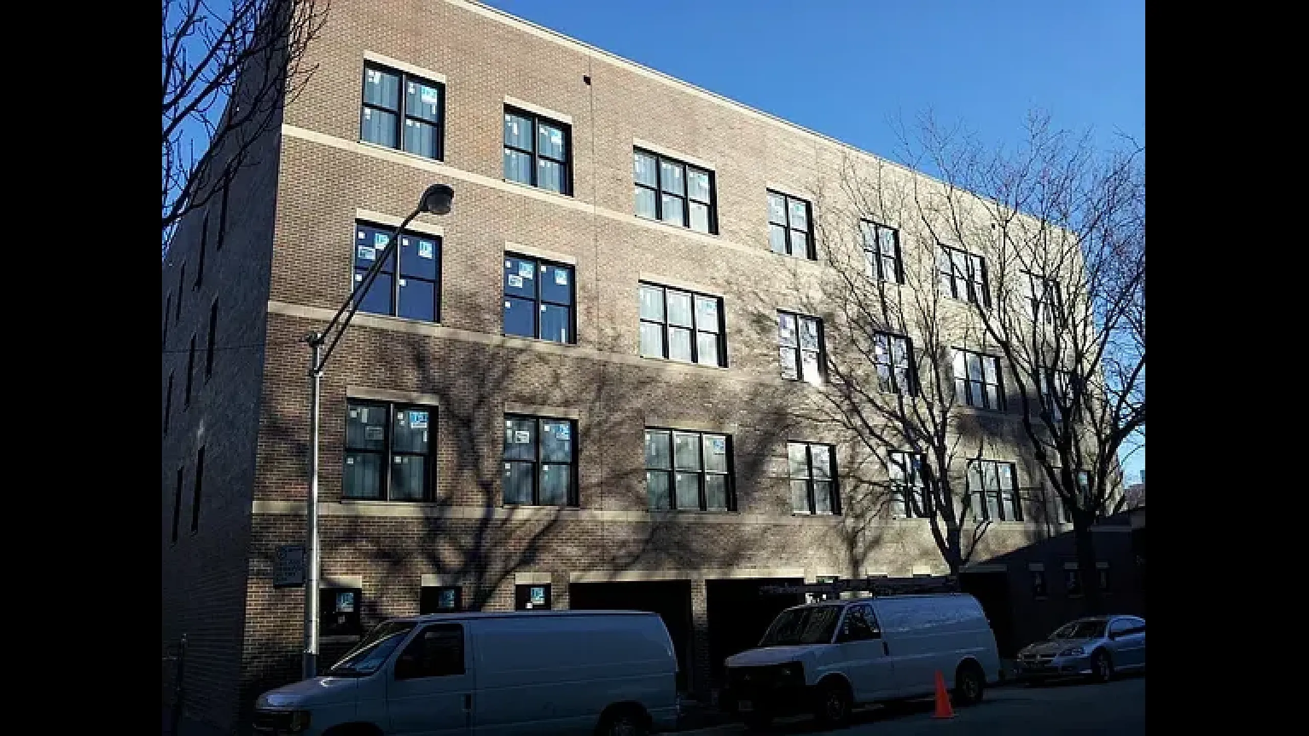 Chic urban apartment building with large windows and modern facade, offering bright and welcoming living spaces.