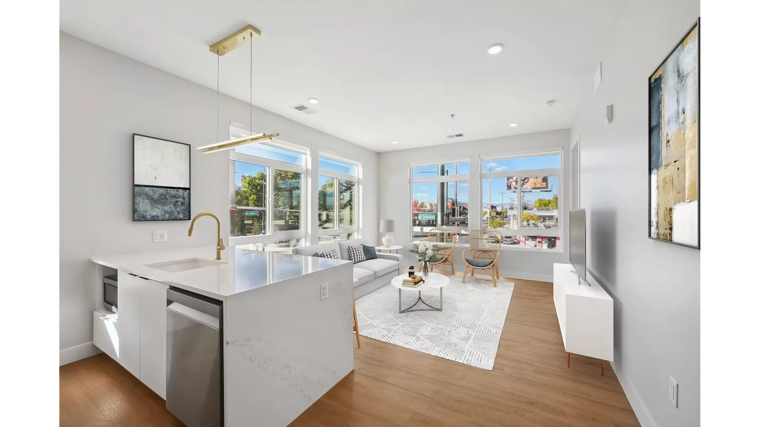 Bright and modern living space with large windows, sleek kitchen island, and cozy seating area.