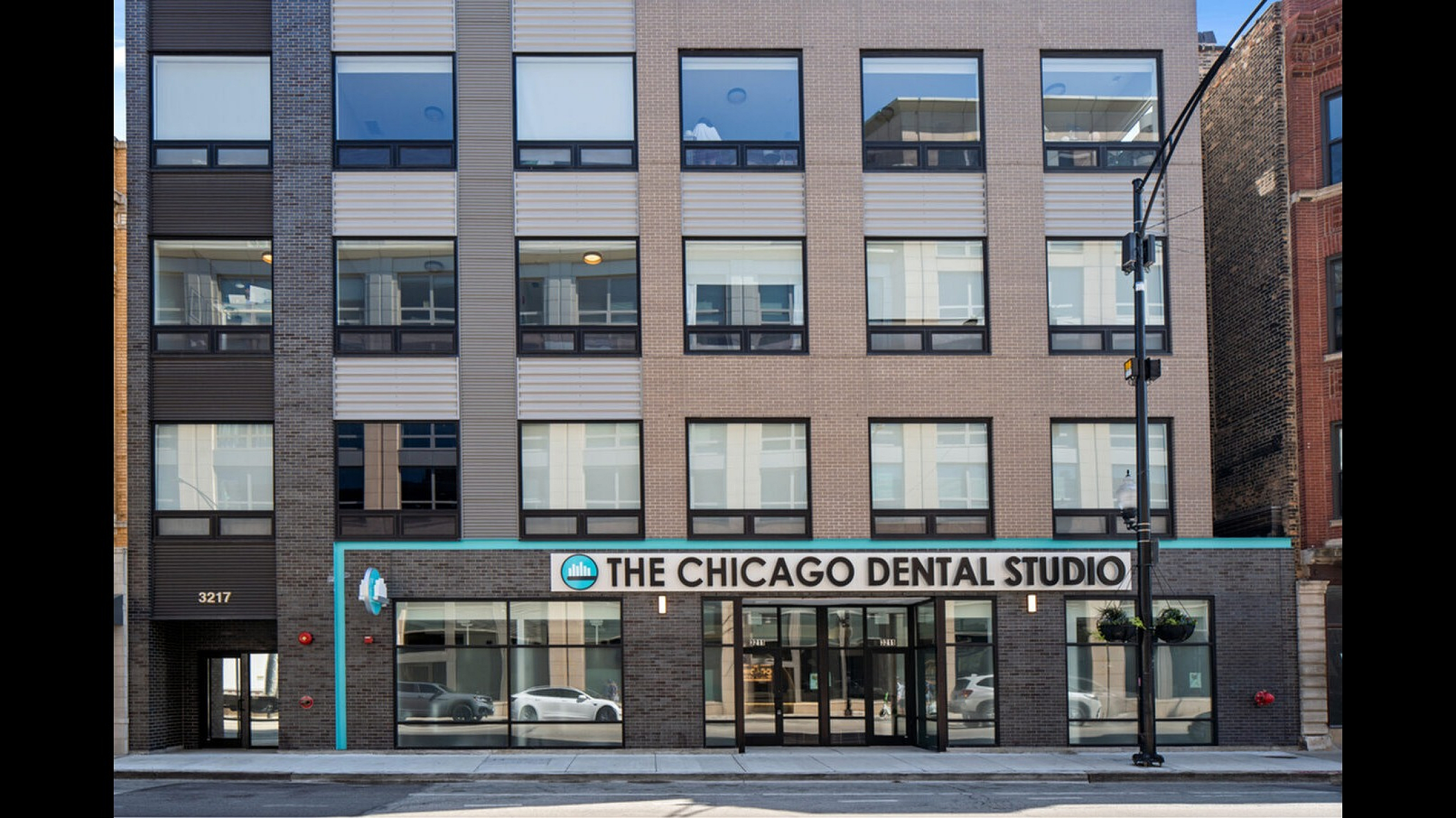 Modern urban building exterior with large windows and retail storefront on ground level, featuring sleek architectural design.