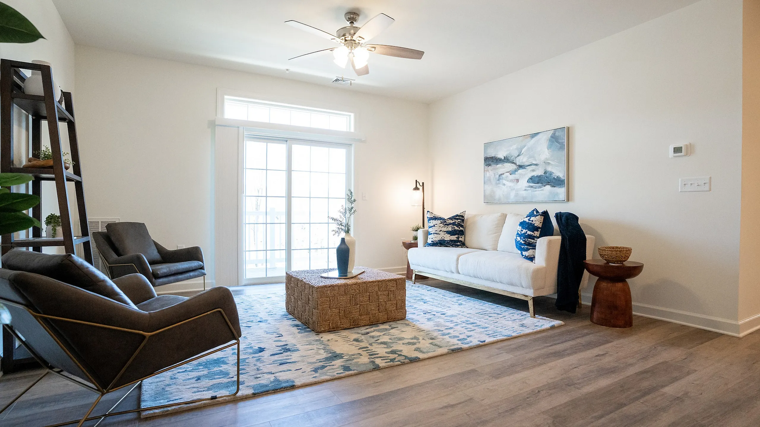 Elegant living room featuring modern furniture, stylish decor, and a large window with abundant natural light.