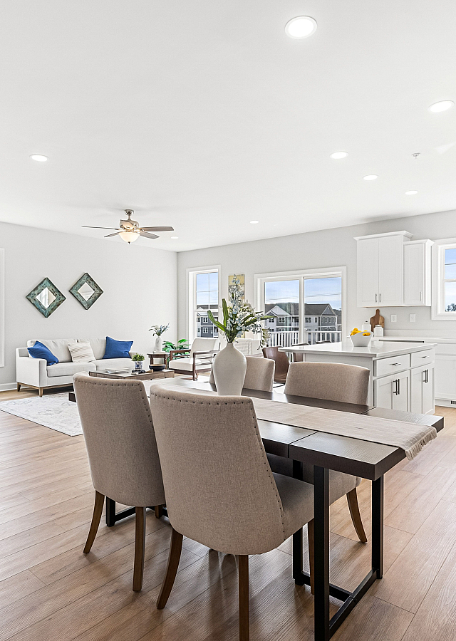 Bright and modern open-concept living space with elegant dining area, cozy seating, and a sleek kitchen, perfect for sophisticated living.