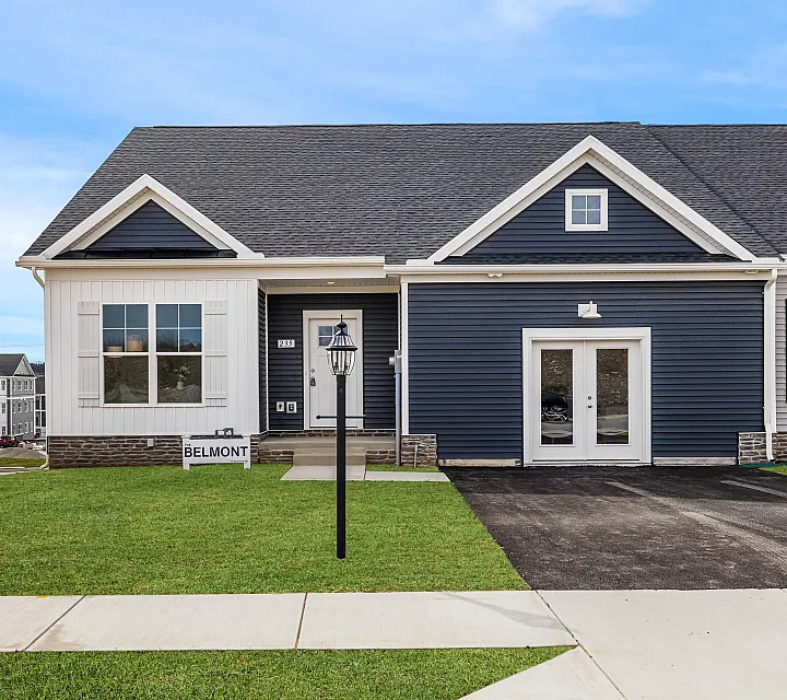 Charming Belmont home with a modern blue facade, inviting double doors, and picturesque green lawn in a peaceful neighborhood setting.