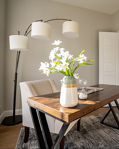 Bright and elegant home office with a modern wood desk, stylish floor lamp, and inviting armchair, perfect for productivity and inspiration.