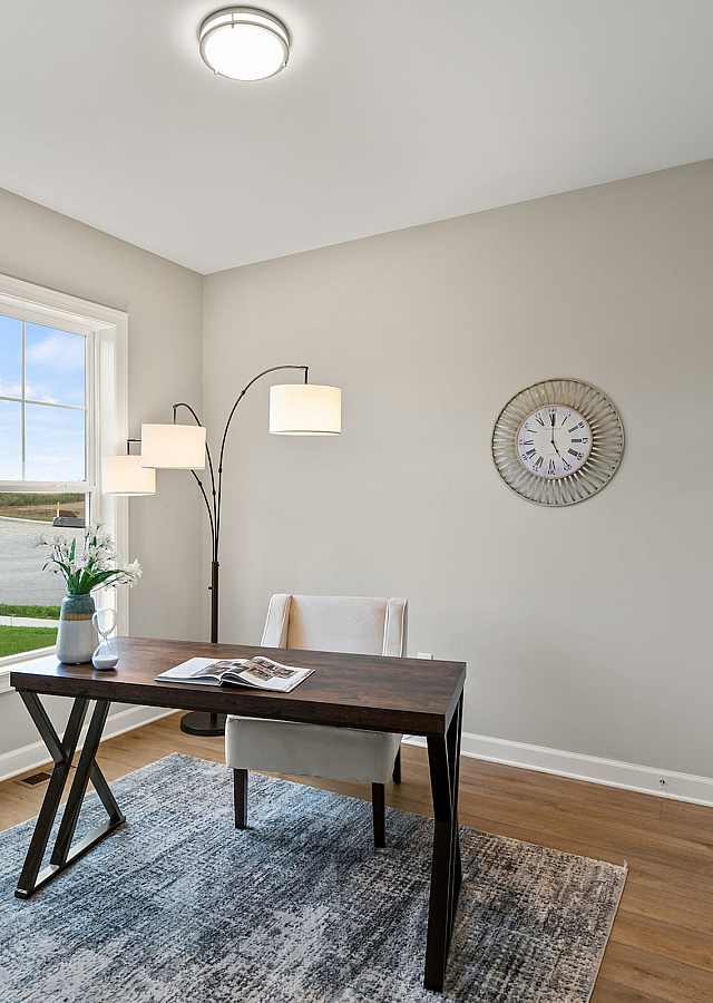 Bright home office with large window, modern desk, and stylish decor creating a perfect work-from-home environment.
