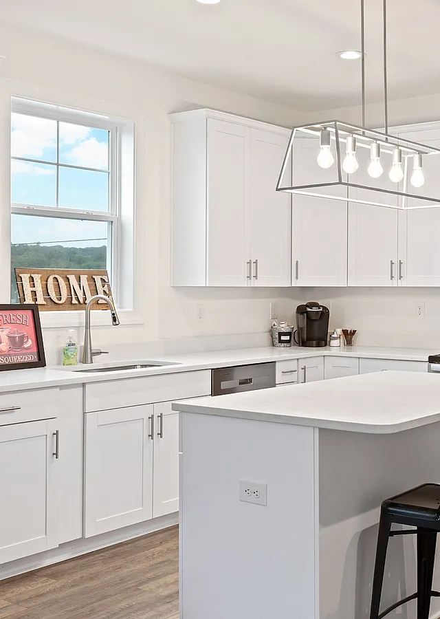 Bright and airy modern kitchen with sleek white cabinetry, a chic island, and stylish lighting fixtures, perfect for gourmet cooking and entertaining.