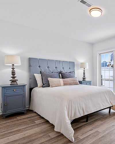Inviting bedroom with a cozy bed, elegant nightstands, and a scenic view through large windows, perfect for relaxation.