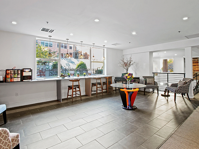 Inviting communal lounge with large windows, modern decor, and cozy seating, perfect for relaxation and socializing.