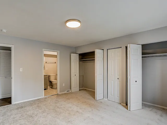 Bright and spacious bedroom featuring multiple closets and an ensuite bathroom, perfect for comfortable living.