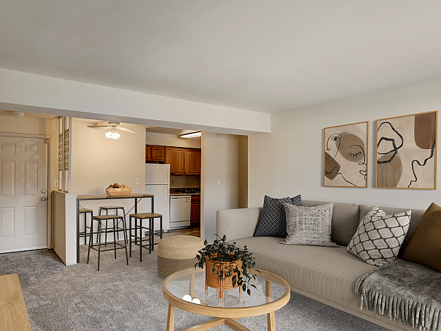 Modern living room with cozy sectional sofa, stylish abstract art, and open kitchen concept. Inviting spaces perfect for relaxation and entertaining.