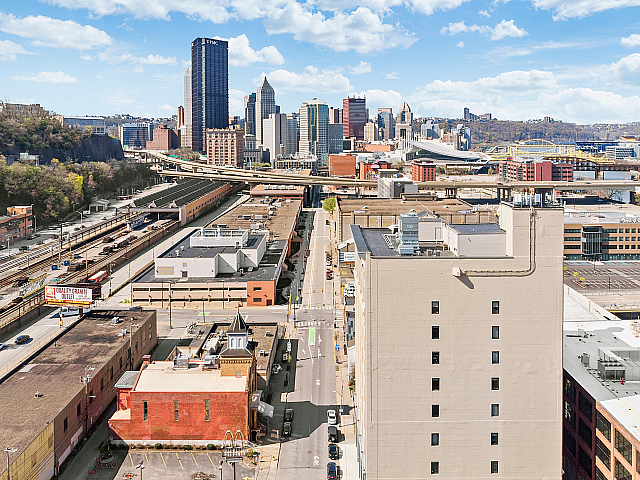 Vibrant urban landscape showcasing a dynamic city skyline under clear skies, with bustling roadways and a mix of historic and modern architecture.