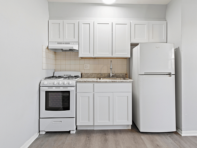 Modern kitchen with white cabinetry, sleek countertops, and essential appliances for a cozy cooking space.