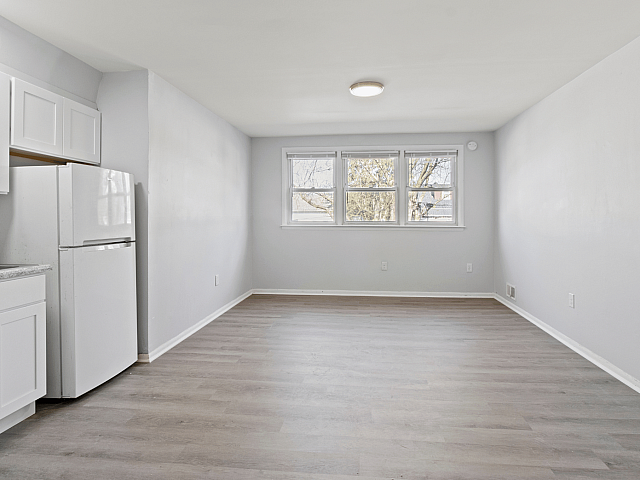 Bright and inviting open-plan living area with modern kitchen and large window providing natural light.