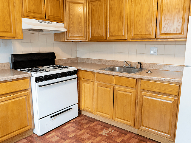 Cozy kitchen with warm wooden cabinetry, classic gas stove, and durable countertops.