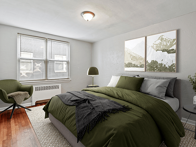 Elegant bedroom featuring a cozy bed with olive green bedding, stylish chair, and minimalist decor creating a serene atmosphere.