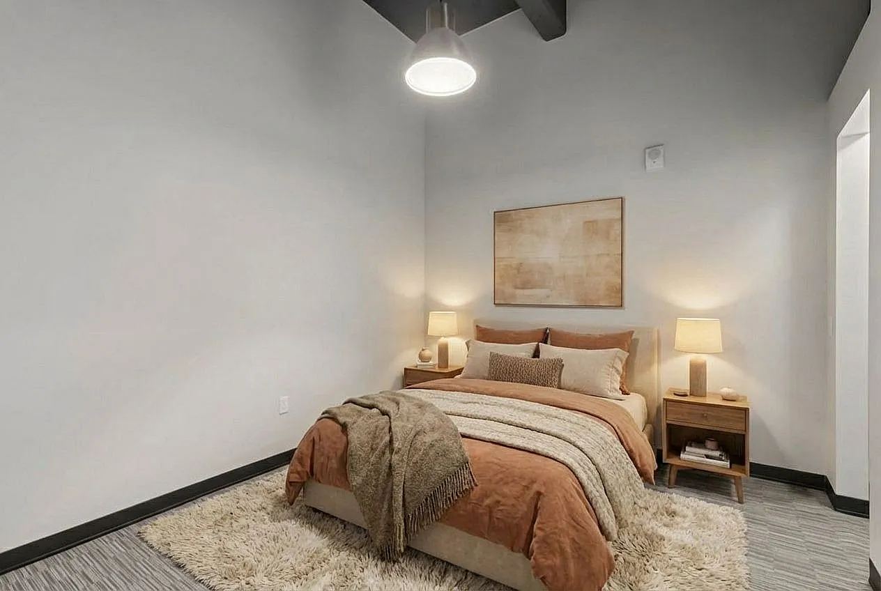 Cozy bedroom with modern decor, featuring a plush bed with warm tones, soft lighting, and stylish accents.