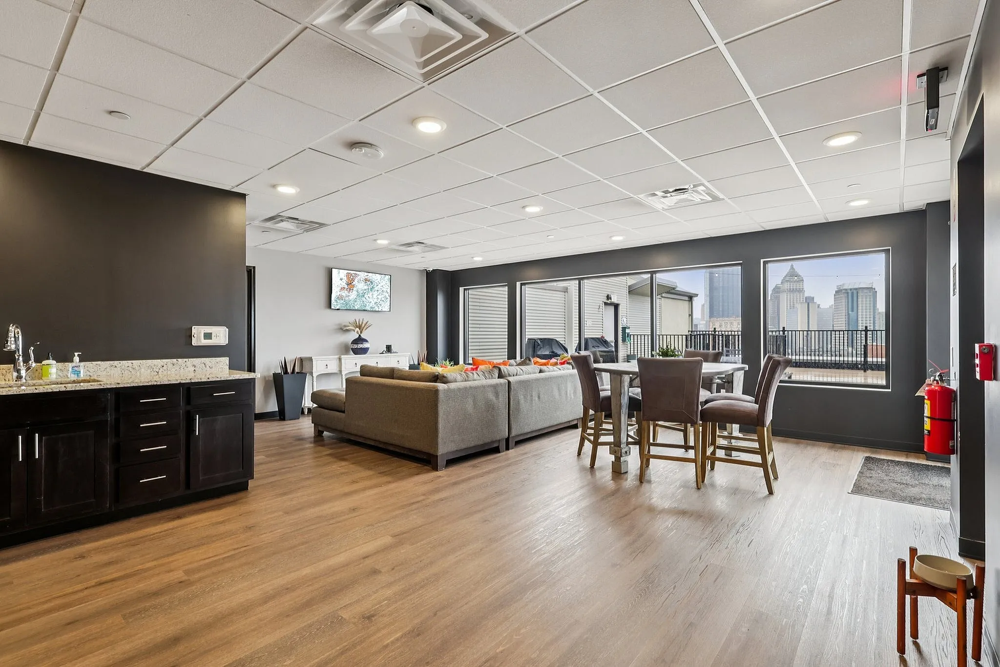 Modern open-concept living area with sleek kitchen, elegant dining space, and expansive windows offering stunning city views.
