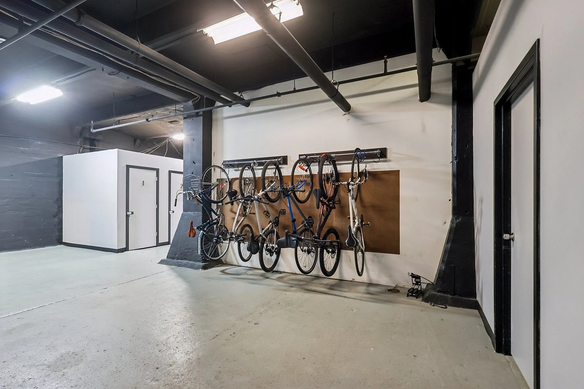 Modern bicycle storage room with wall-mounted bike racks and sleek industrial design.