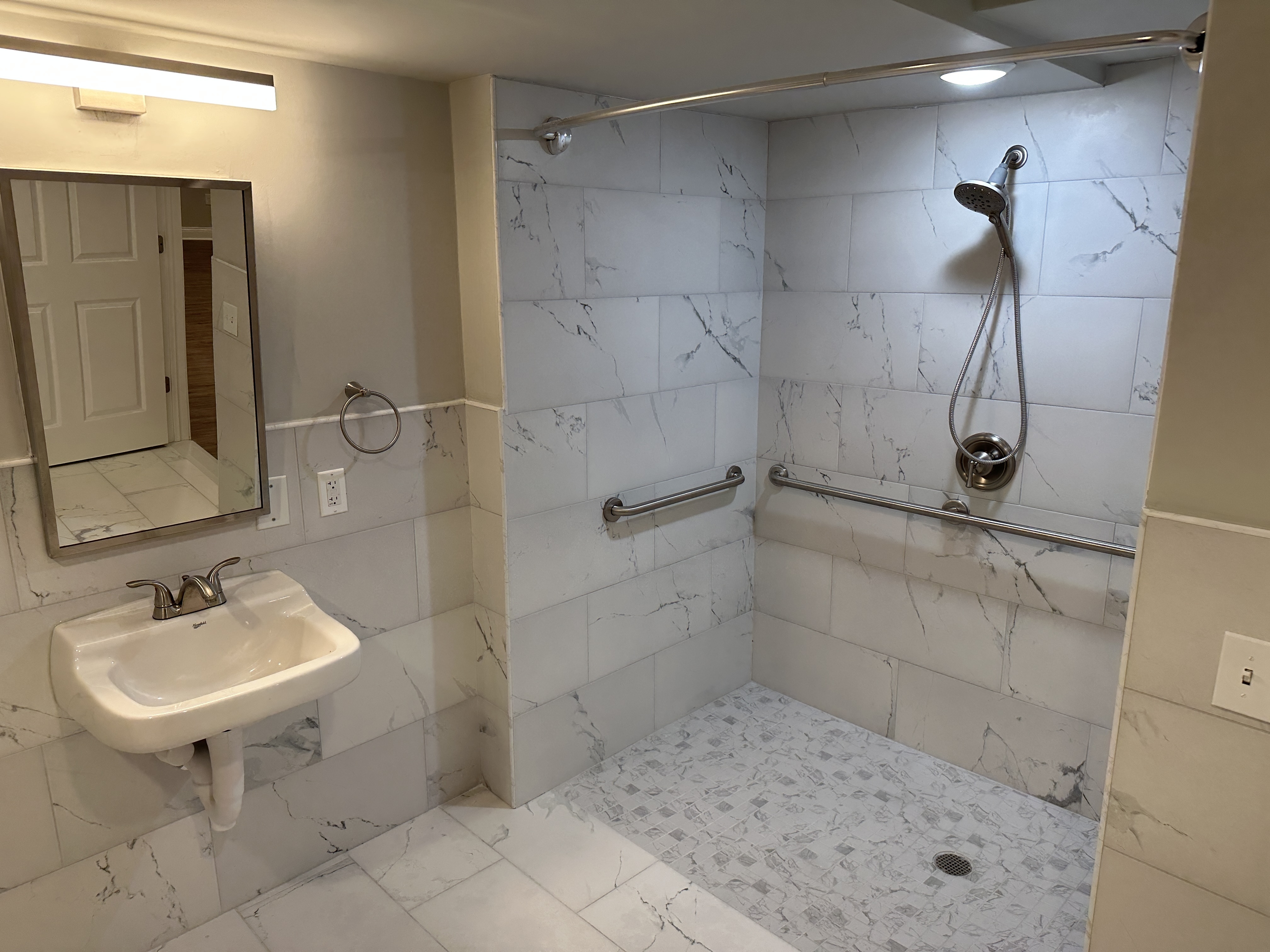 Modern bathroom with elegant marble tiles, spacious walk-in shower, and stylish vanity.