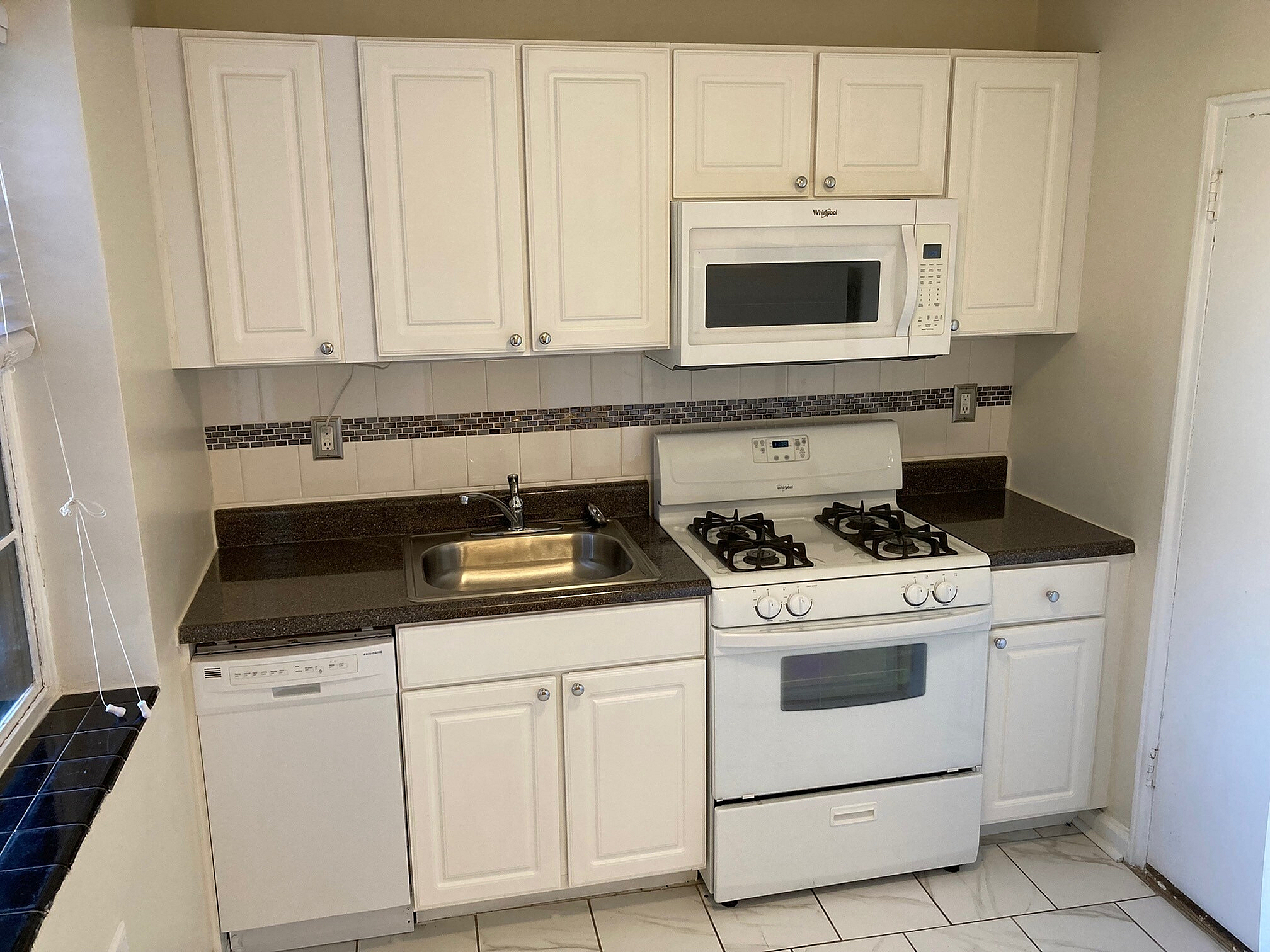 Charming kitchen with modern white cabinetry, sleek countertops, and integrated appliances, perfect for culinary adventures.