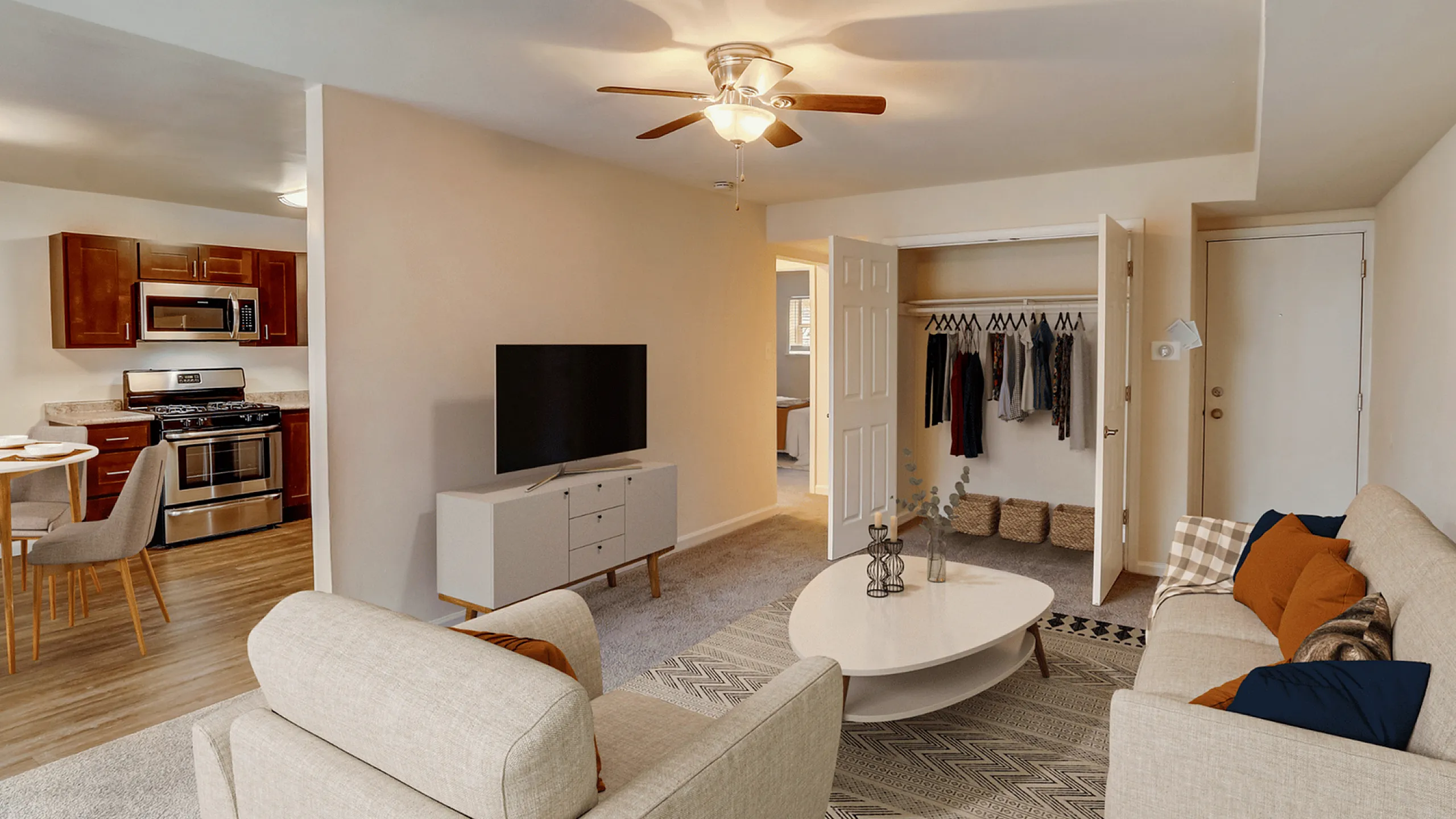 Modern apartment living room with cozy seating and open kitchen layout.