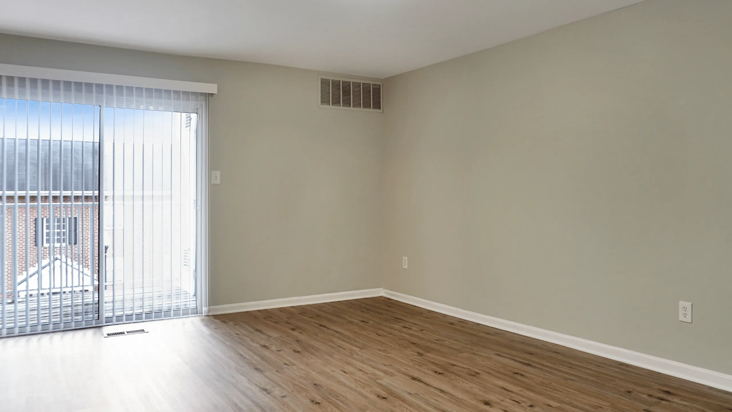 Modern apartment living room with elegant flooring and patio view.