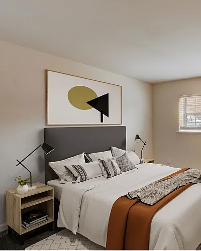 Stylish bedroom with contemporary decor, featuring a comfortable bed, geometric artwork, and ample natural light from a large window.