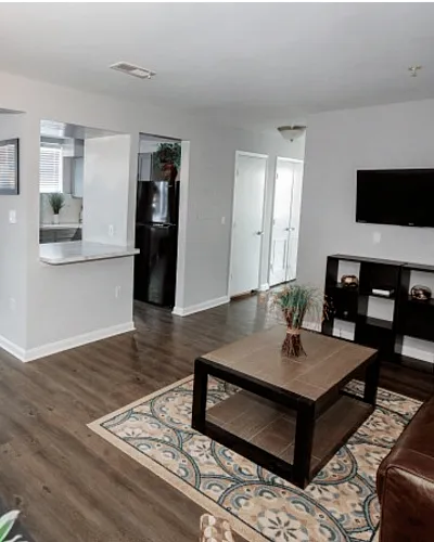 Bright and modern open-concept living area with hardwood floors, glass dining table, and cozy seating arrangement.