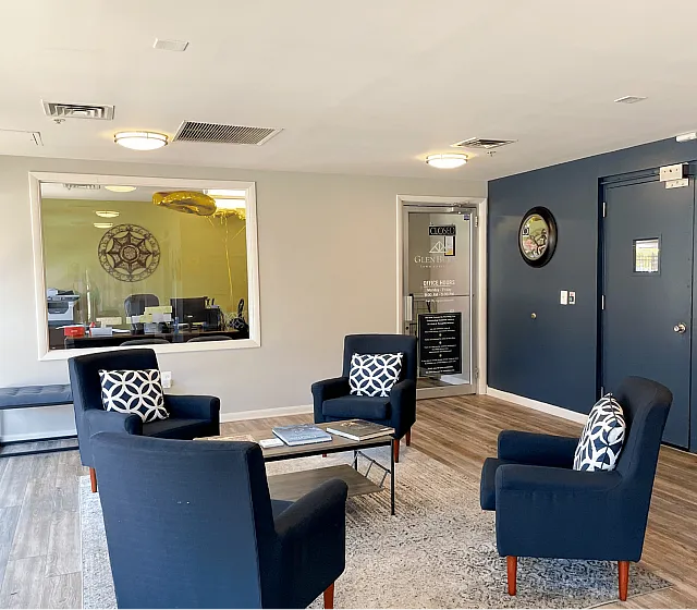 Stylish lounge area with modern navy blue armchairs and a sleek coffee table set against a chic decor.