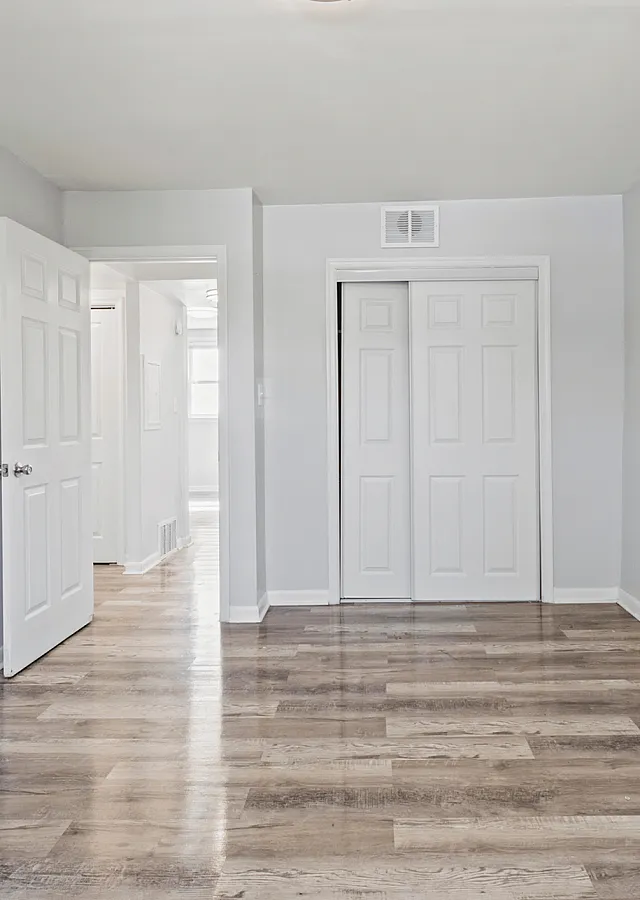 Inviting empty room with polished wood flooring and ample natural light.
