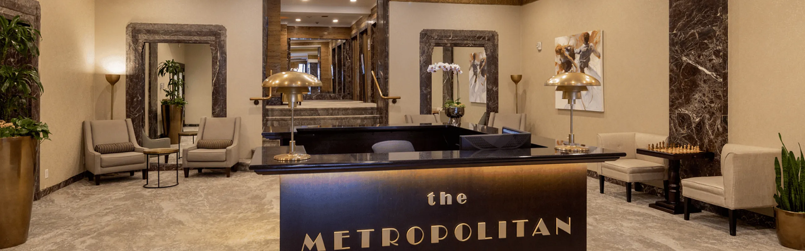 Luxurious hotel lobby entrance with modern design, featuring plush seating and a grand chandelier.