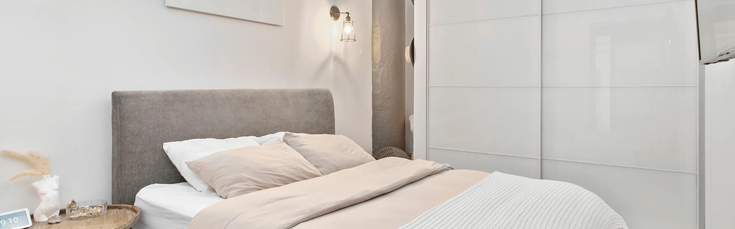 Stylish bedroom with a cozy bed, modern lighting, and sleek storage solutions.