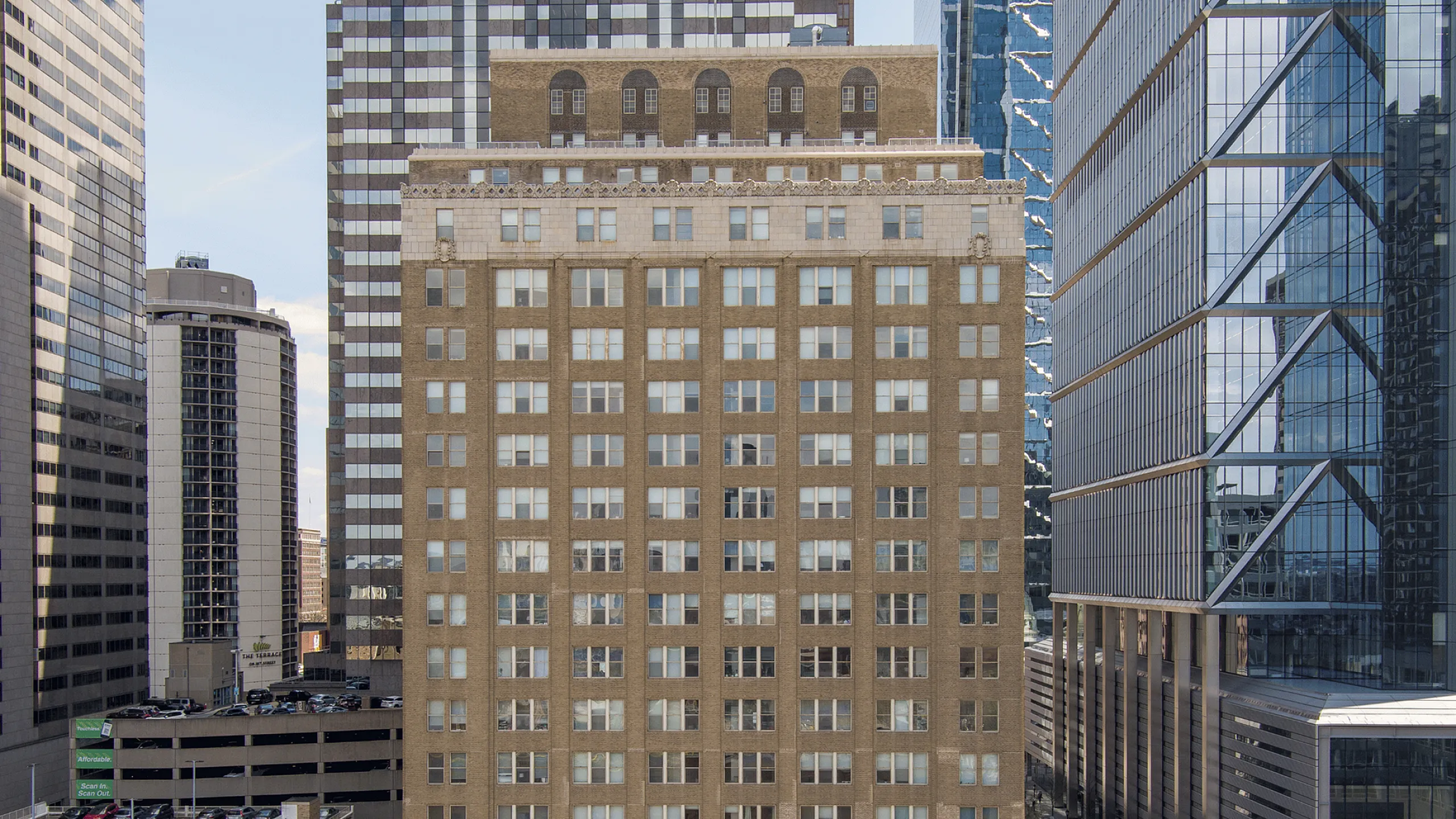 Charming urban apartment building surrounded by modern skyscrapers, offering a blend of classic architecture and city convenience.