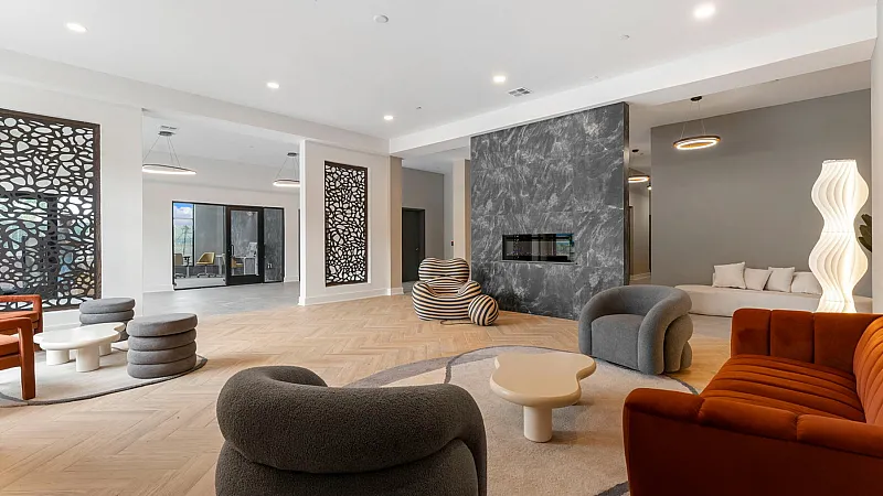 Chic contemporary lounge with modern furniture, artistic lighting, and a sleek herringbone floor, perfect for relaxation and gatherings.