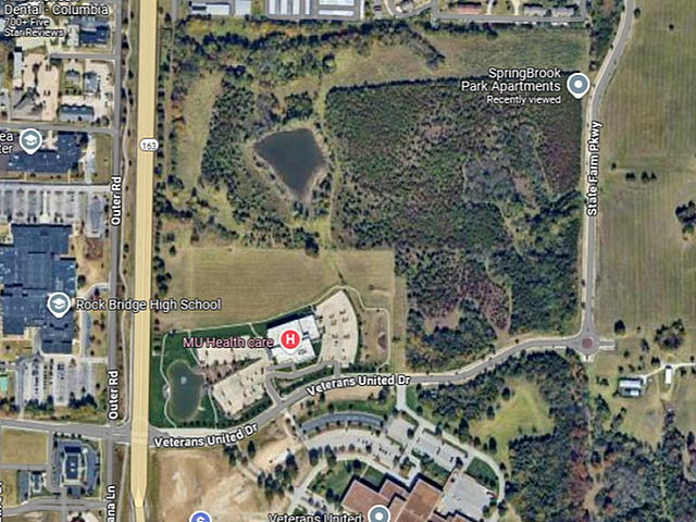 Aerial view highlighting SpringBrook Park Apartments near lush green spaces, sports fields, and convenient urban amenities.