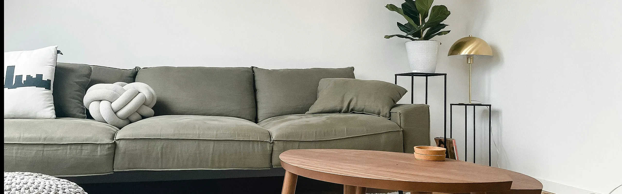 Inviting living room with a plush green sofa, stylish coffee table, and modern decor under soft lighting.