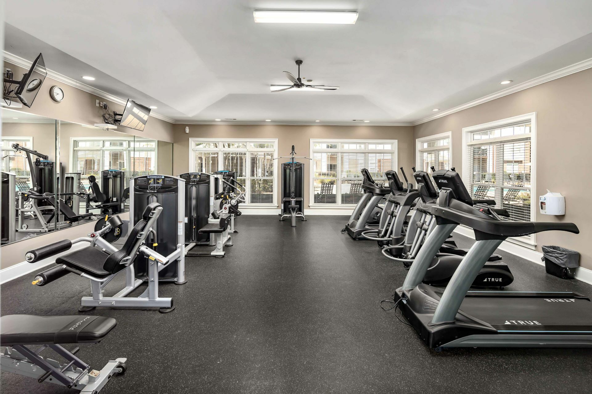 Spacious fitness center featuring a variety of equipment, including treadmills, ellipticals, strength machines, and free weights at Abberly Woods Apartments in Charlotte, NC