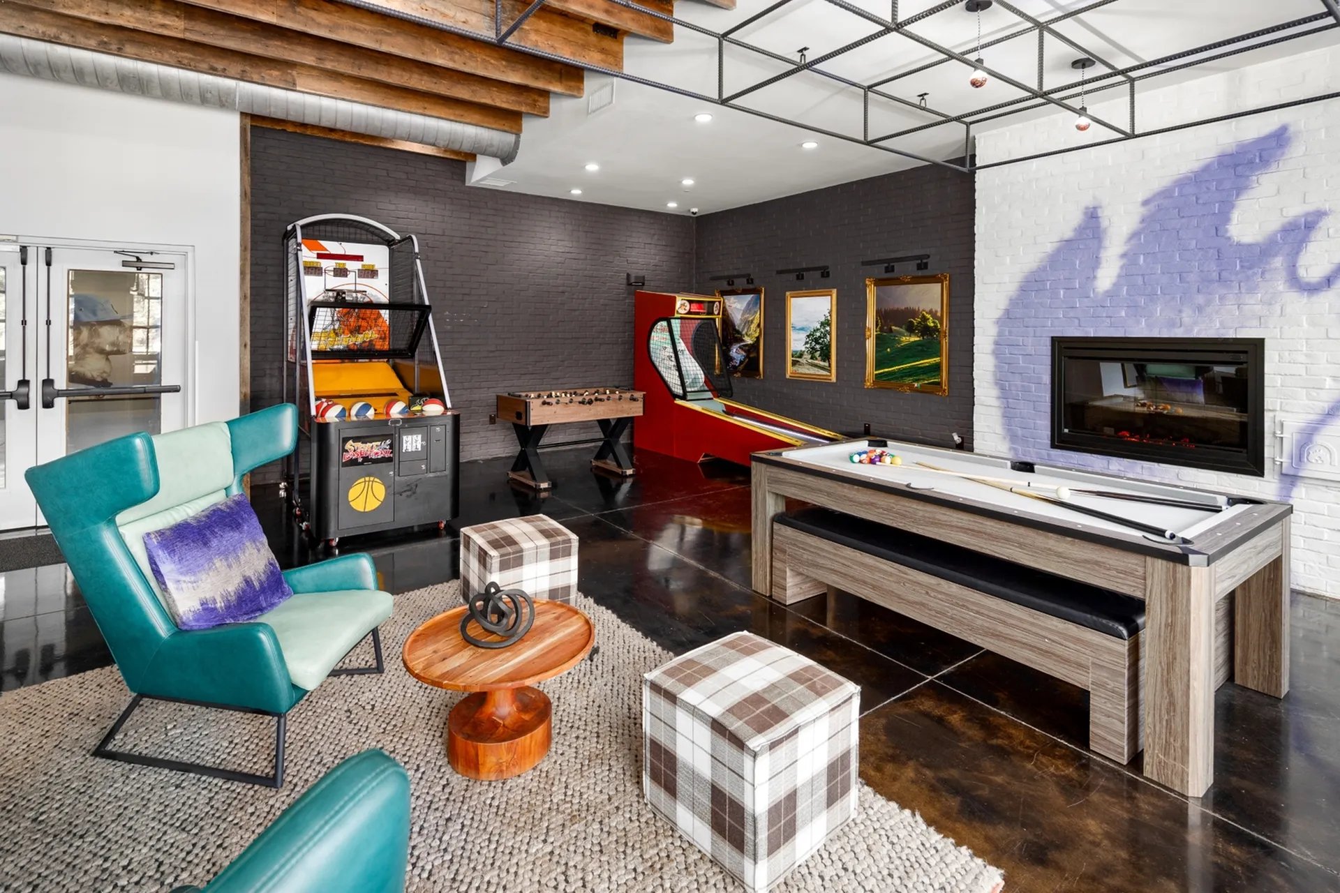 Vibrant entertainment room with modern decor featuring a pool table, basketball game, foosball, and cozy seating for ultimate relaxation.