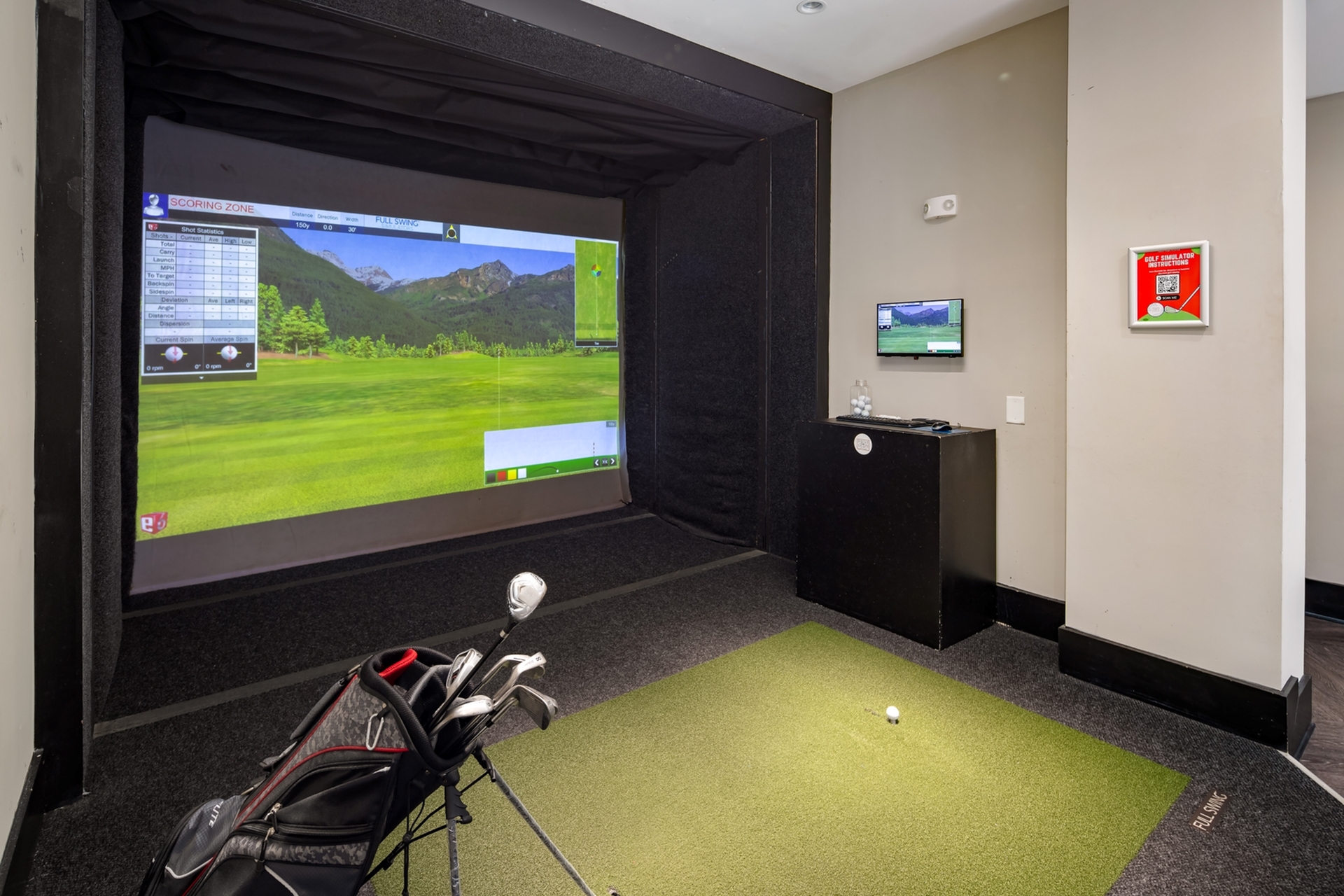 Luxurious golf simulator room featuring an interactive virtual course with golf clubs and a putting green, perfect for indoor practice and entertainment.