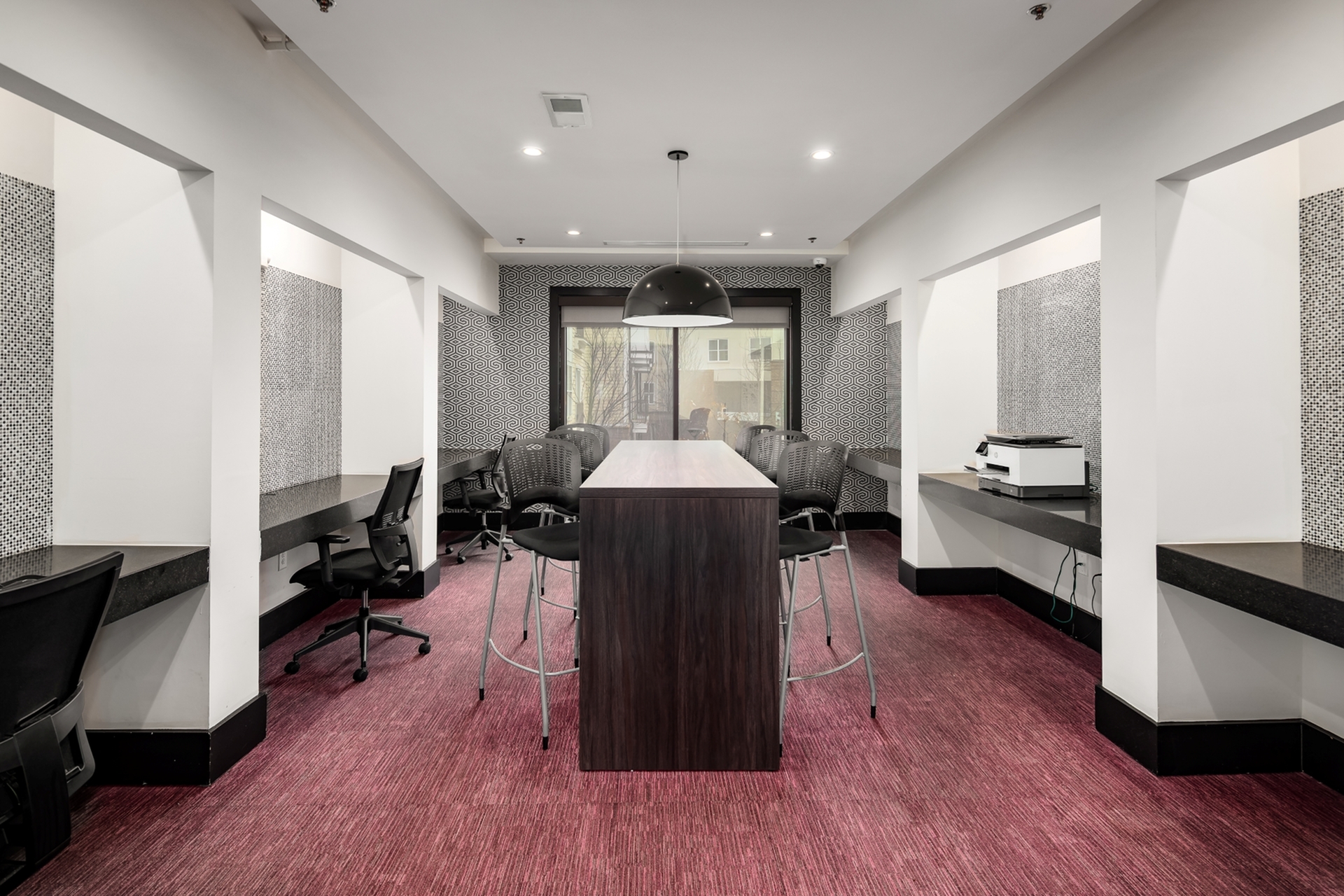 Modern workspace with sleek high-top table, stylish chairs, and vibrant carpet, perfect for productivity and collaboration.