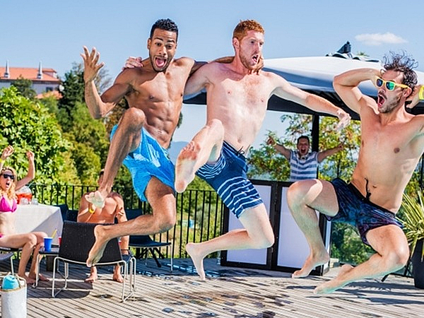 Vibrant poolside scene with friends joyfully jumping into a refreshing, azure blue pool, set against a lush green backdrop, perfect for lively summer gatherings.