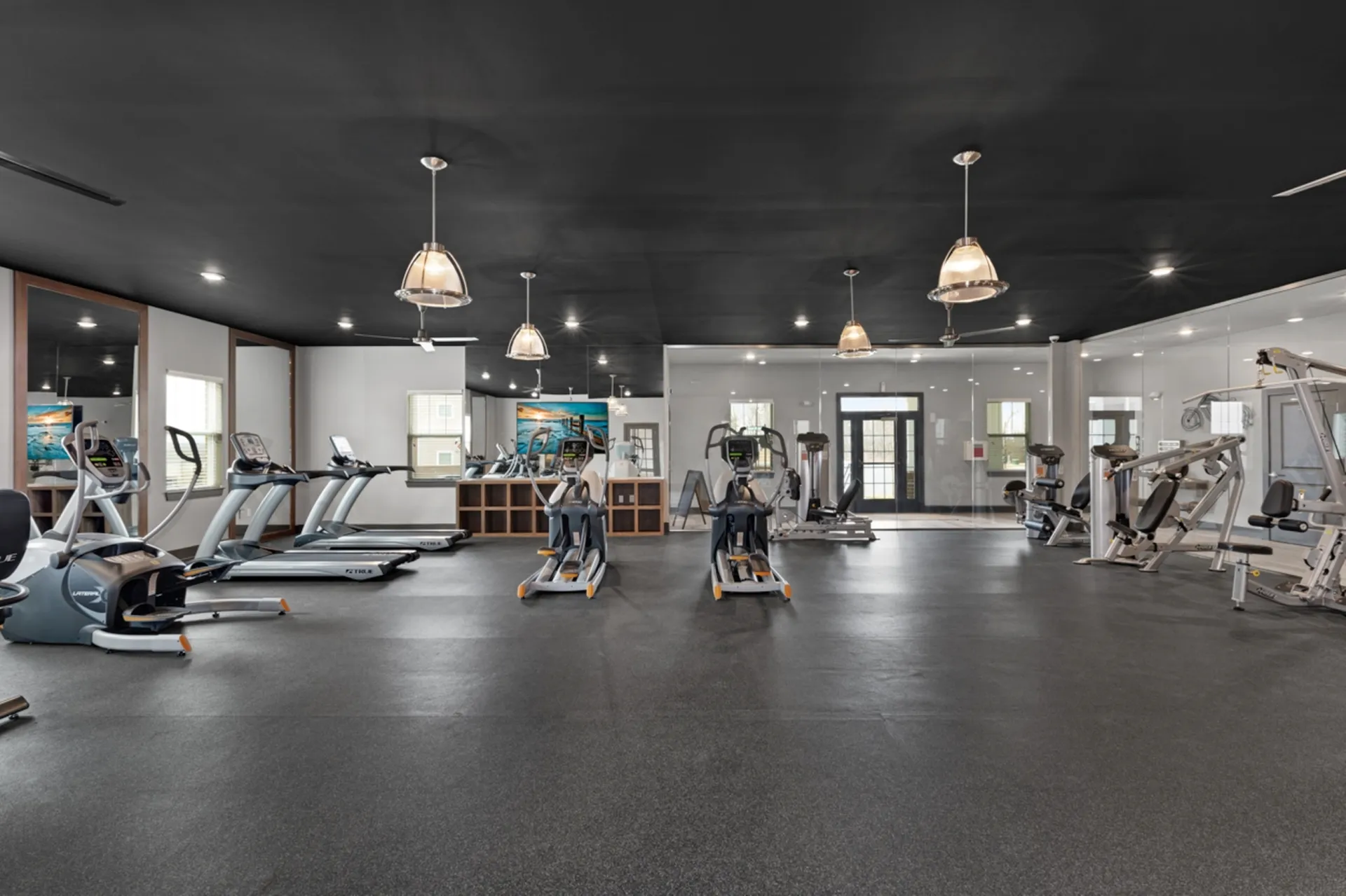 Spacious and modern fitness center with state-of-the-art equipment and stylish lighting.