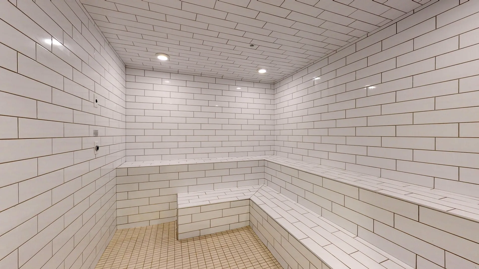 Luxurious private steam room with modern white tiles, offering a serene and relaxing environment.
