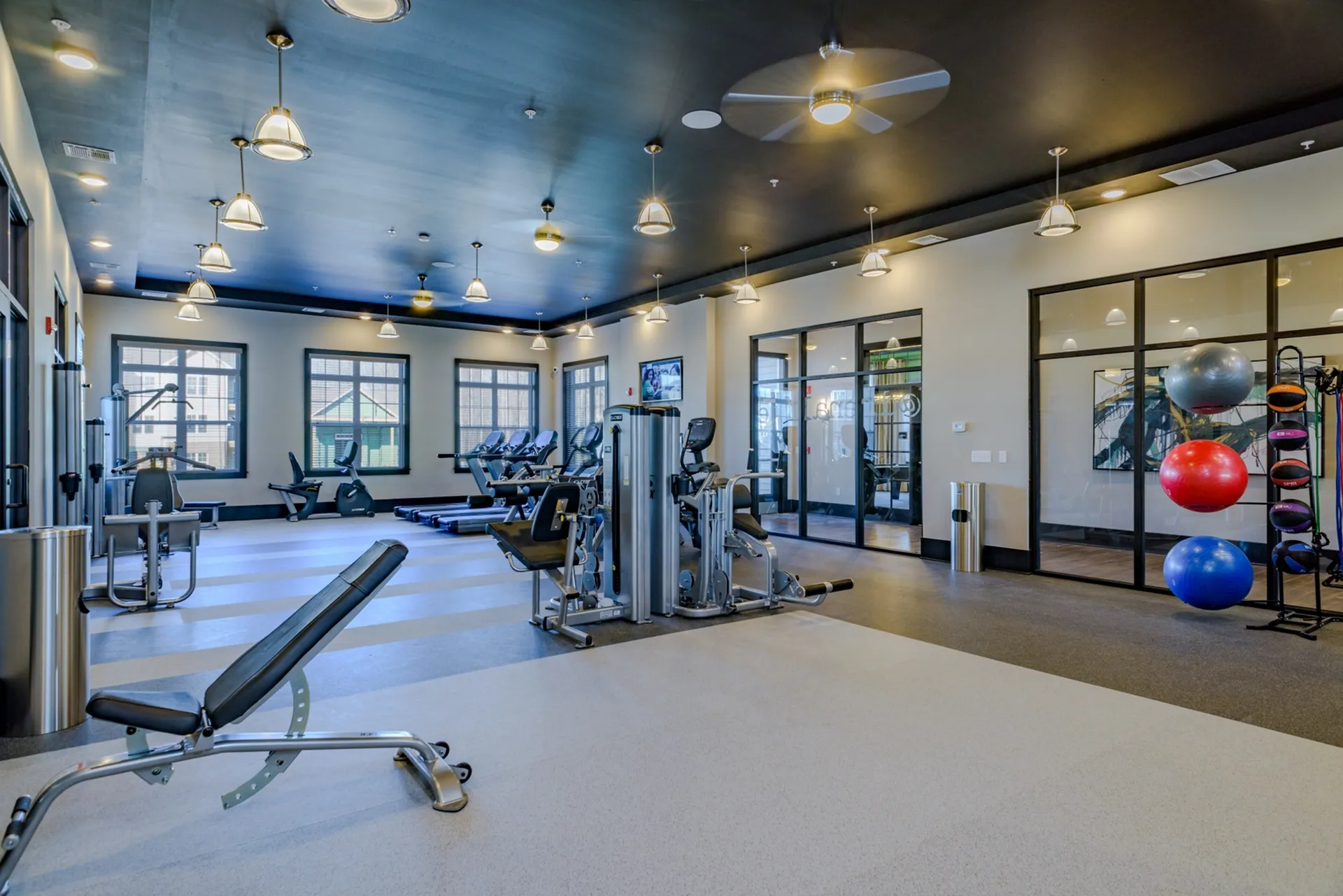Modern apartment gym with state-of-the-art equipment, vibrant lighting, and spacious layout for comfortable workouts.