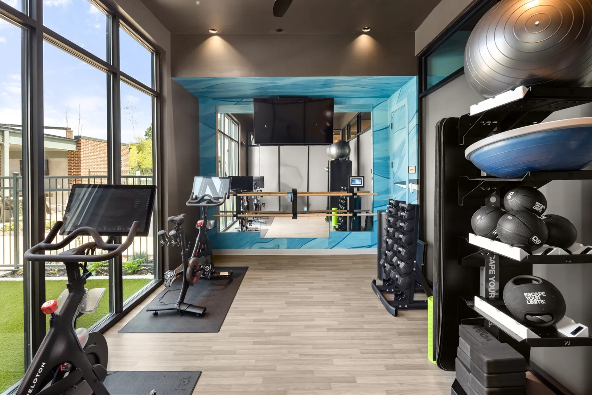Luxurious apartment fitness room with modern equipment, bright natural light, and stunning views.
