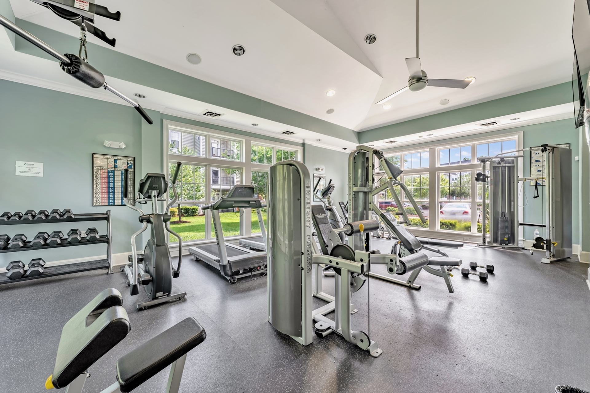 Bright and modern fitness center equipped with state-of-the-art gym machines and large windows offering a scenic view.