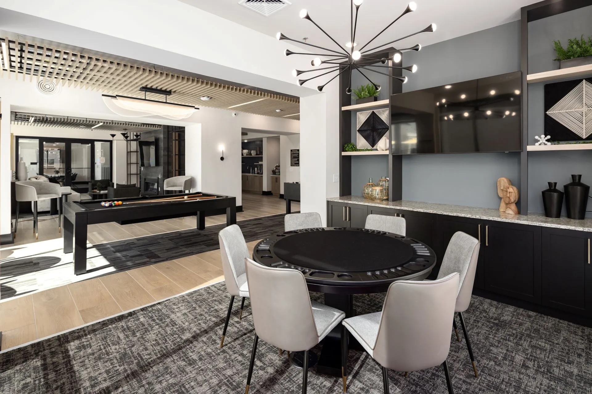 Chic and modern recreation area featuring a stylish pool table, contemporary lighting, and a cozy seating nook, perfect for entertaining.